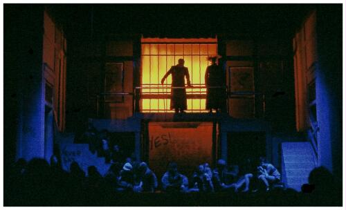 (Image: Two Actors Stand on the Balcony Viewing the Cast Below)