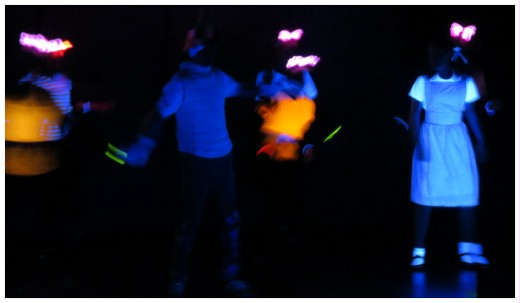 (Image: Closeup in the Jitterbug Scene of the
 Cast with Glowing Costumes)