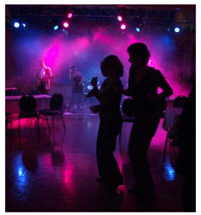 (Image: Dancers are Silhouetted by the Band and Stage Lighting)