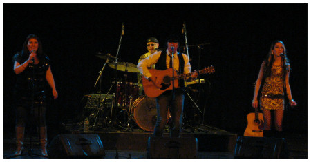 (Image: Guitarist, Drummer and Two Vocalists on
 Stage)