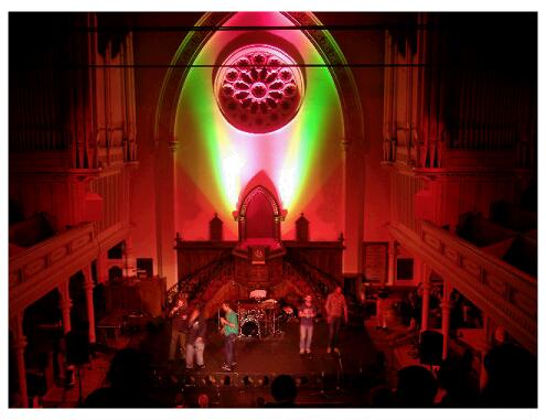 (Image: A Bright Stage with both Pink and Green Wall Lighting)