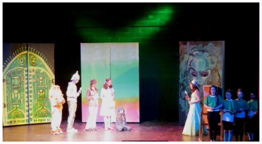 (Image: The Cast in the Wizard's Chamber with
 Emerald City Choir Members to Either Side)